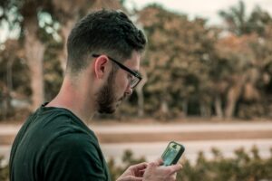 person using mobile phone outdoors showing habits that affect focus and concentration