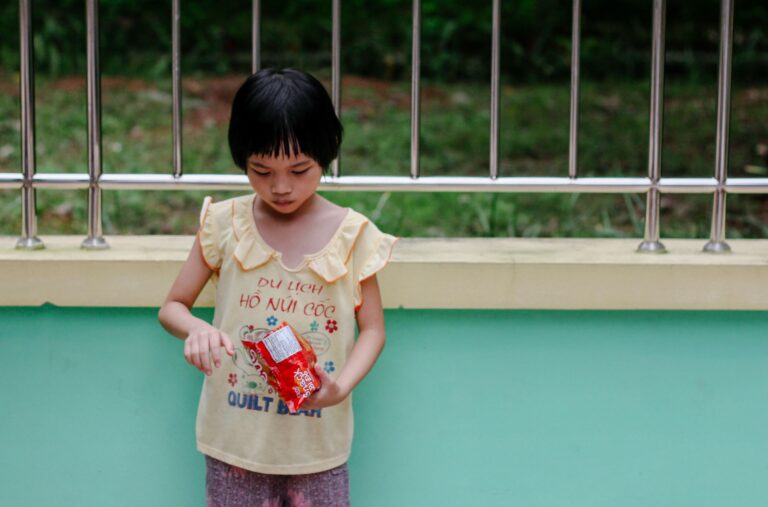 A young girl eating chips outdoors, reflecting the growing junk food addiction in children