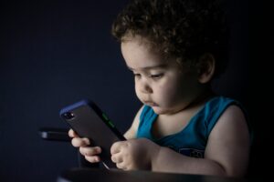 A child using a mobile phone alone, illustrating mobile addiction in children and excessive screen time.