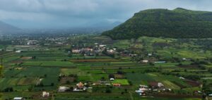 A panoramic view of green fields, hills, and rural settlements in India, reflecting the interconnected lives, landscapes, and communities that shape the nation's identity.