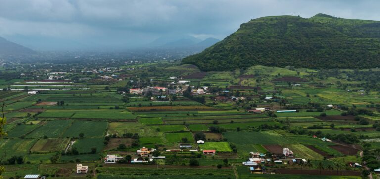 A panoramic view of green fields, hills, and rural settlements in India, reflecting the interconnected lives, landscapes, and communities that shape the nation's identity.