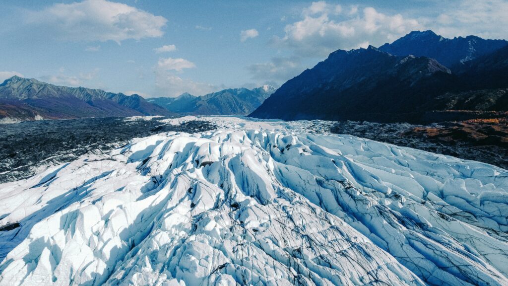 A vast glacier surrounded by snow-covered mountains